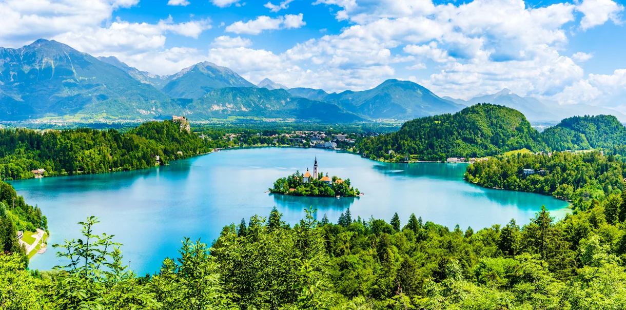 Prekrasen razgled na blejsko jezero, okoliške hribe in otoček s cerkvijo sredi jezera